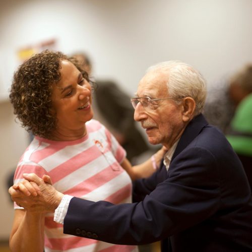 volunteer dancing with elderly man